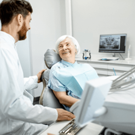 Senior patient smiling at dentist during routine checkup