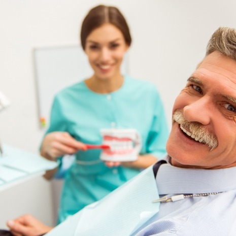 Man smiling during denture repair visit