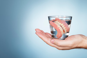 dentures soaking in a glass